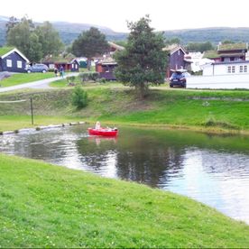 Badedam og campingplass i bagrunn